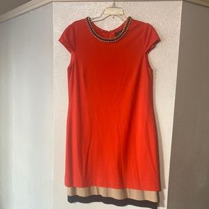 Orange sleeve dress with tan and black bottom. Gold chain black ribbon